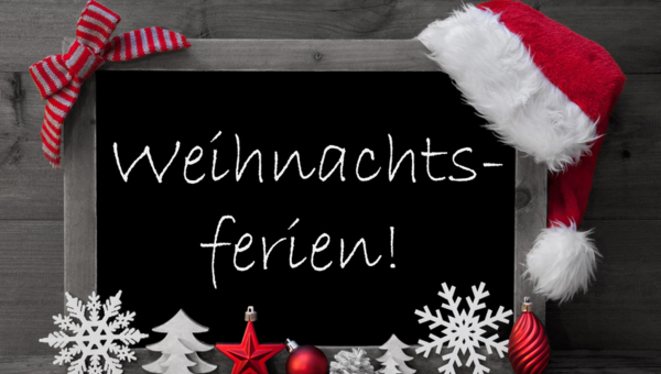 Auf einer Schiefertafel mit Weihnachtsschmuck steht "Weihnachtsferien" geschrieben